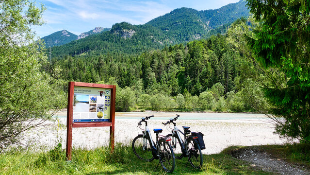 Zwei Fahrräder am Isarradweg und vor einer Infotafel