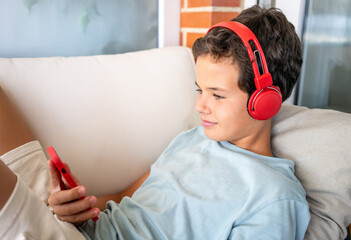 leisure, children, technology and people concept - smiling boy with smartphone and headphones...