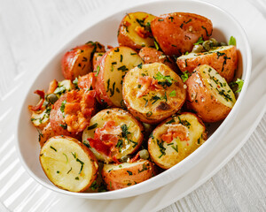 Herbs Garlic Potatoes in white bowl, top view