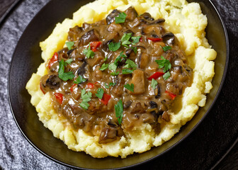 potato mash topped with mushroom gravy in bowl