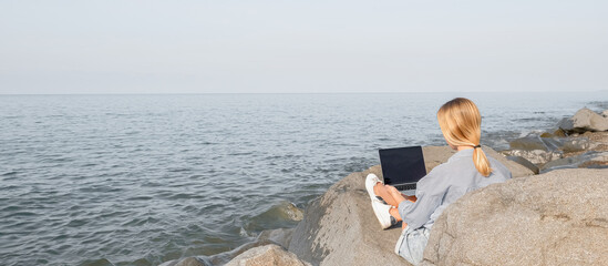 Remote work.Girl freelancer works remotely on the sea shore. workation, remote work,WFVH,Van Life vibes work from vacation home,work travel,remotely work.Travelling.Work from vacation remotely