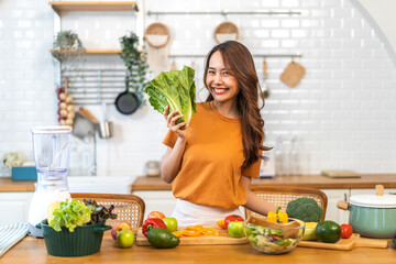 Portrait of beauty body slim healthy asian woman having fun cooking and preparing cooking vegan food healthy eat with fresh vegetable salad on counter in kitchen at home.Diet.Fitness and healthy food