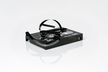 DAT (Digital Audio Tape) cassette with twisted tape isolated on white