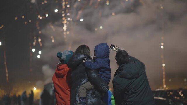 Man taking selfie pictures of his family during night fireworks show