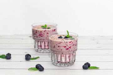 Homemade blueberry smoothie with mint on a wooden background. Detox diet