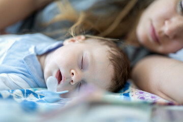 Obraz na płótnie Canvas Little baby sleeping next to her mother.