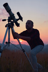 Astronomer looking at the skies with a telescope.