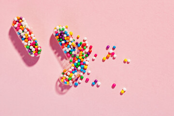 Medical pill capsules filled with colorful sugar sprinkles, creative concept