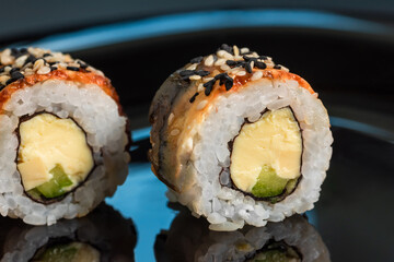 Japanese fresh sushi rolls on black background.