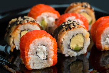 Traditional fresh japanese sushi rolls on a black background