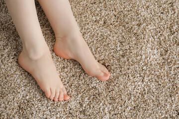 Woman on soft brown carpet at home, top view. Space for text