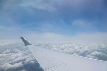 Throug window of aircraft during flight, we are able to see beautiful blue skies as we fly view wing