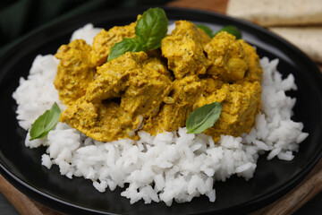 Delicious rice and chicken with curry sauce on plate, closeup