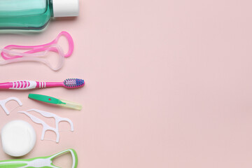 Tongue cleaners and other oral care products on pink background, flat lay. Space for text