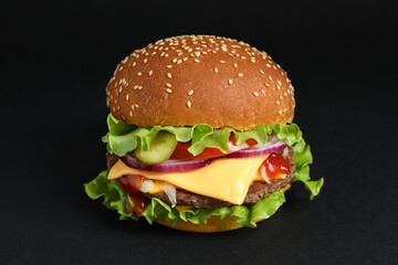 Delicious burger with beef patty and lettuce on black background