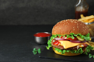 Delicious burger with beef patty on dark table, space for text