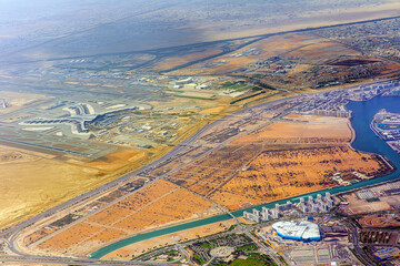 Airplane view of Abu Dhabi International Airport, streets, roads and residential buildings of the city