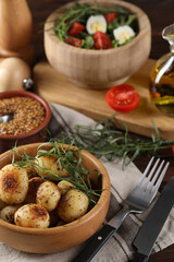 Delicious grilled potatoes with tarragon, mustard and salad on table