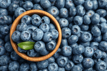 Tasty fresh blueberries and bowl, top view