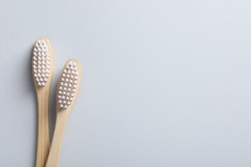 Bamboo toothbrushes on white background, flat lay. Space for text