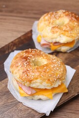 Delicious bagels with ham and cheese on table, closeup
