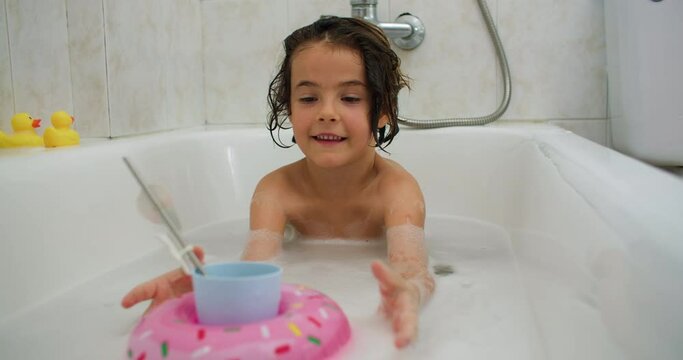 Bubbly Delight: A Playful Kid Having a Blast in the Bath, Embracing a Happy Childhood. High quality 4k footage