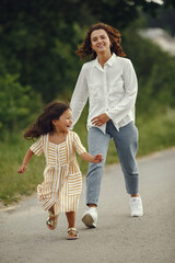 Mother with daughter playing in a summer field