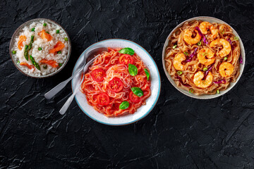 Konjac pasta and rice. A variety of shirataki dishes, overhead flat lay shot on a black slate background