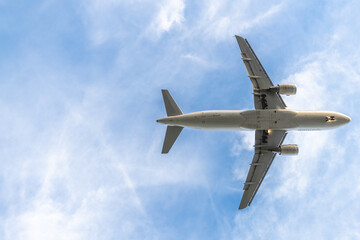 Low angle view of a airplane in flight against the blue sky with the white clouds