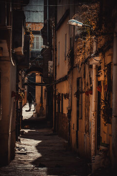 The narrow valley in the old town (Medina) of Tunisian city Bizerte with the yellow walls and paved path.