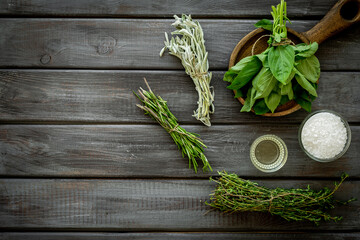 Cooking background with fresh green herbs on wooden board, top view