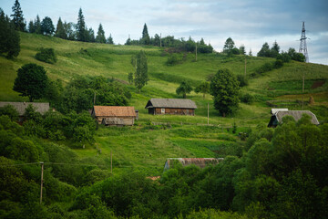 Obraz na płótnie Canvas Wooden traditional houses against the backdrop of a mountain landscape, Ukrainian Carpathians.
