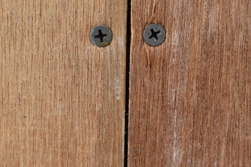 Photo of two screws in a wooden wall