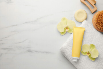 Flat lay composition with spa products and beautiful flowers on white marble table. Space for text