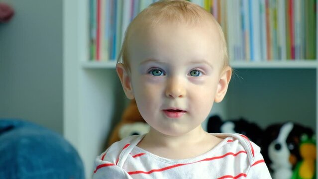 A sincere smile of a one-year-old child. Little boy looks at the camera and smiles.