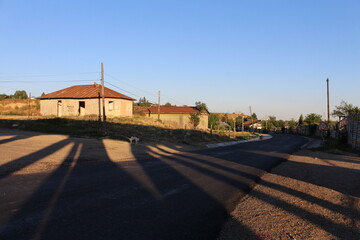 Fototapeta na wymiar A road with a building and shadows on the ground