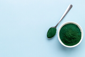 Spirulina algae powder in bowl and spoon, super food, top view