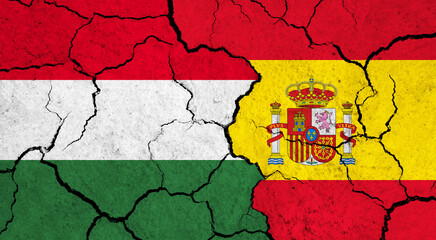 Flags of Hungary and Spain on cracked surface - politics, relationship concept