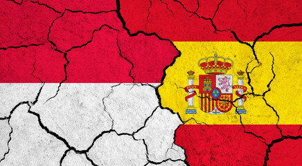 Flags of Indonesia and Spain on cracked surface - politics, relationship concept