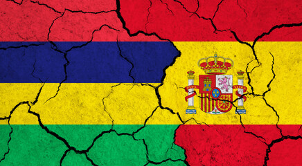 Flags of Mauritius and Spain on cracked surface - politics, relationship concept
