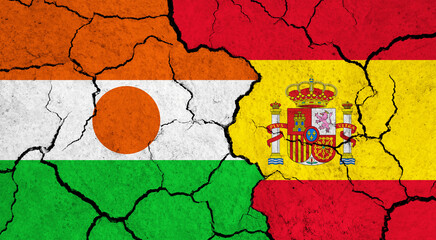 Flags of Niger and Spain on cracked surface - politics, relationship concept