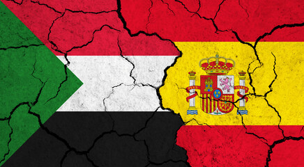 Flags of Sudan and Spain on cracked surface - politics, relationship concept