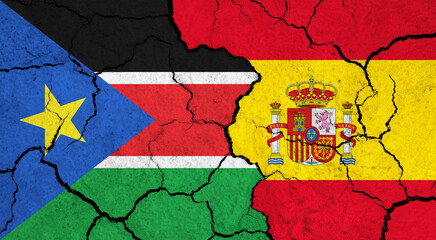 Flags of South Sudan and Spain on cracked surface - politics, relationship concept