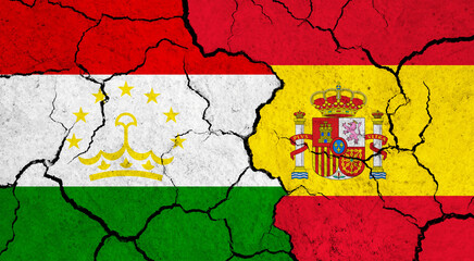 Flags of Tajikistan and Spain on cracked surface - politics, relationship concept