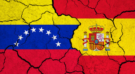 Flags of Venezuela and Spain on cracked surface - politics, relationship concept