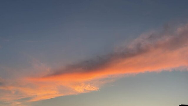 sunset sky with fiery orange clouds. Birds flying in evening heaven.