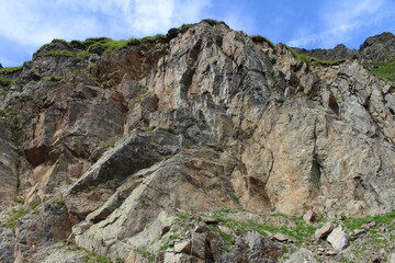 A rocky cliff with grass on top