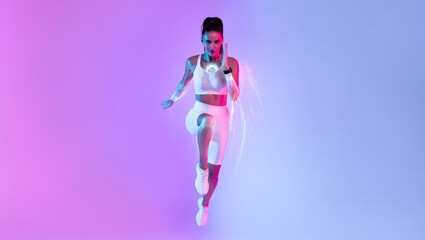 Motivated young athletic woman running over neon background