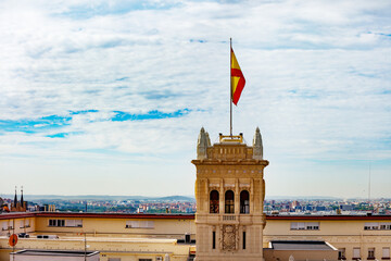 Spain flag on navy headquarters in Madrid over cityscape view