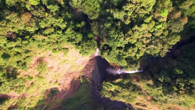 Chute d&rsquo;eau de Tad Fan &agrave; Pakse au Laos en Asie du Sud-Est - Vue a&eacute;rienne d&rsquo;une immense cascade dans un trou au milieu des falaises au couch&eacute; du soleil
